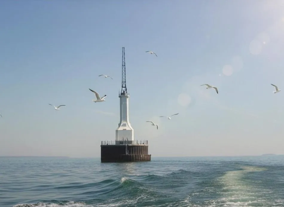 Gravelly Shoal Lighthouse with gulls circling and the wake of a boat in the foreground.