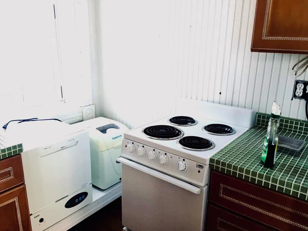 Kitchen range and counters with cherry cabinets against beadboard walls.