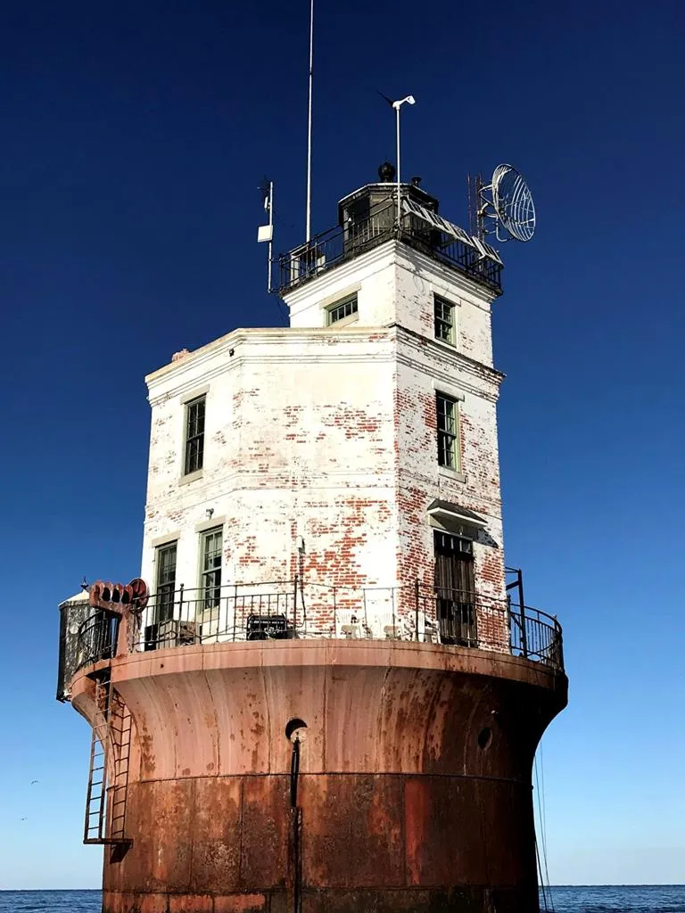 Close view of the keeper's house on top of the iron caisson, with the lantern room, antennas and gallery railing above.